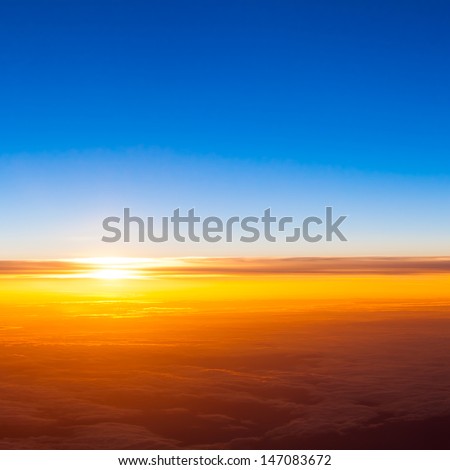 sunset with a height of 10 000 km. Dramatic sunset. View of sunset above clouds from airplane window
