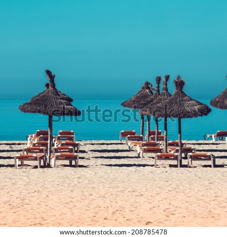 beach scenery with parasol and deck chairs. umbrella and deck chairs