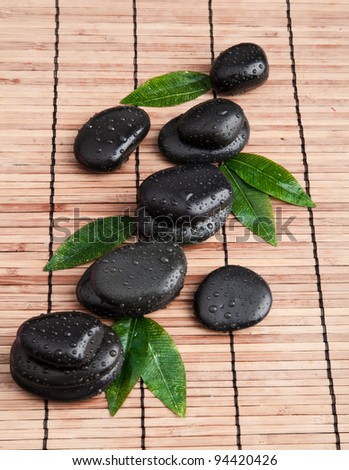 zen stones and leaves with water drops. leaf and basalt stones.