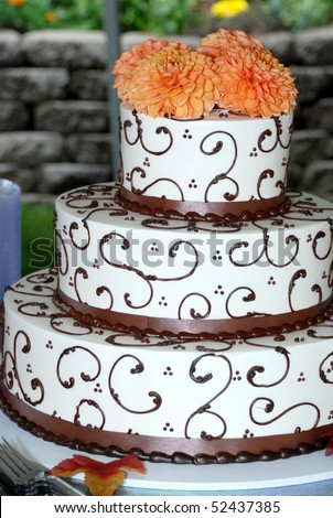 stock photo Very Ornate Brown and white wedding cake with marigolds on top 
