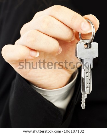 Two silver keys in woman hands in suit
