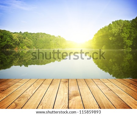 Sunset On Forest Lake And Wooden Board Background