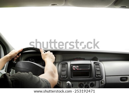 Man\'s hands of a driver on steering wheel of a minivan car