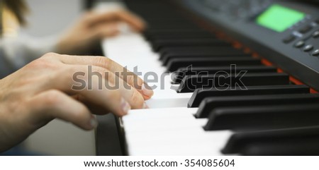 Close-up view on woman hand who play on piano