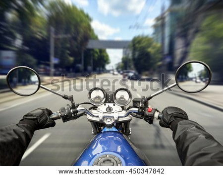 Man is riding a motorcycle on big speed by the asphalt road