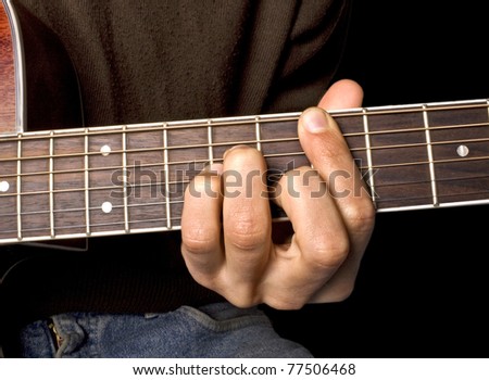 Brown guitar in hands in the guy playing it
