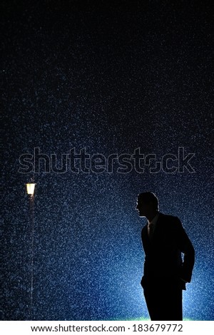 Dramatic photo of a mysterious man in the night rain