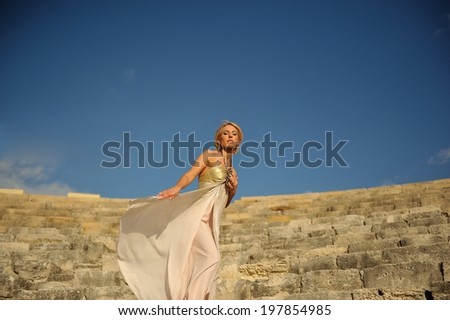 Gorgeous elegant woman at a beautiful antique Roman amphitheater. Goddess.
