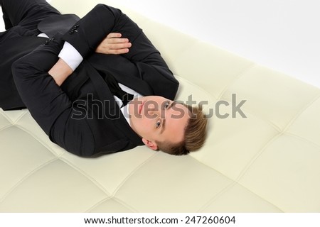 Businessman lying on the couch. Business well, life is good.