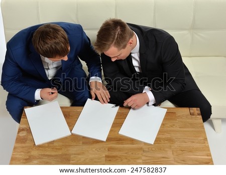 Two people sharing information. Or two business men in the negotiation process. Magazine pages for your text.