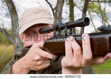 The man Shooting from a gun. Training shooting from an air rifle in the autumn afternoon