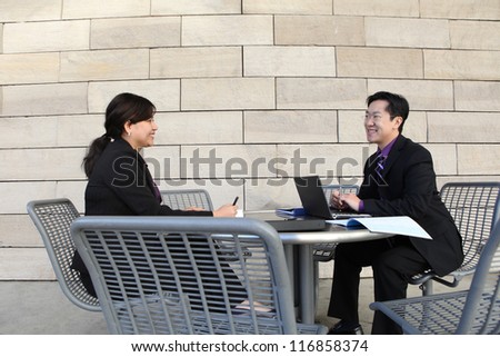Attractive man and woman Chinese business couple working on laptop computer