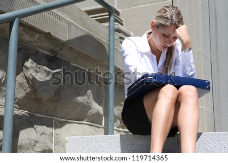 A upset, depressed business woman sitting outside company