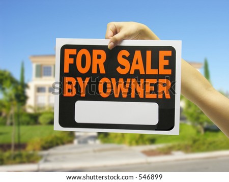 Woman holding for sale sign against house background