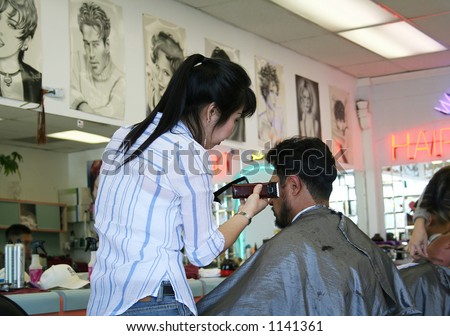 A photo of a man getting his hair cut and styled