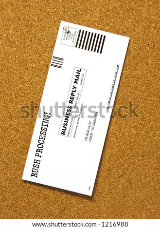 A photo of a business reply mail envelope pinned to a bulletin board