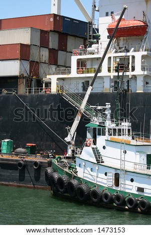 Tug Boat next to cargo ship