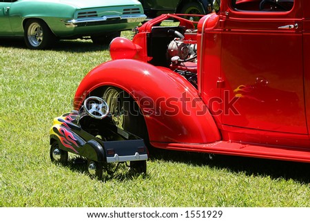 Toy car next to a classic car at a car show