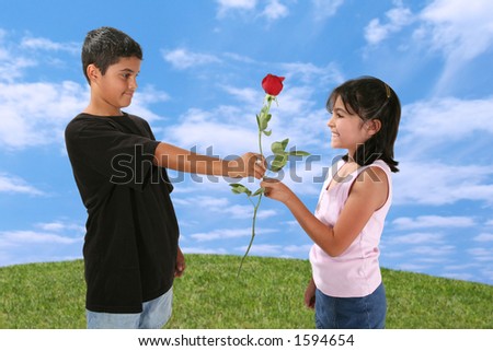 Young boy giving a young girl a red rose