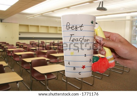 A woman holding a best teacher mug