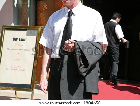 An usher waiting to guide someone down the red carpet