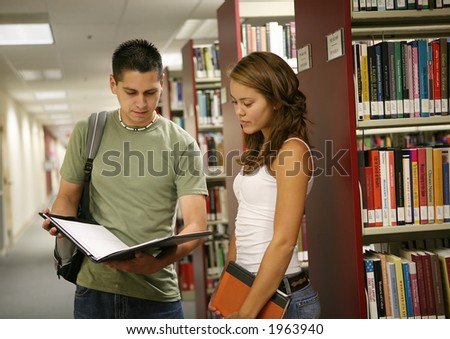 Friends comparing notes in a school library