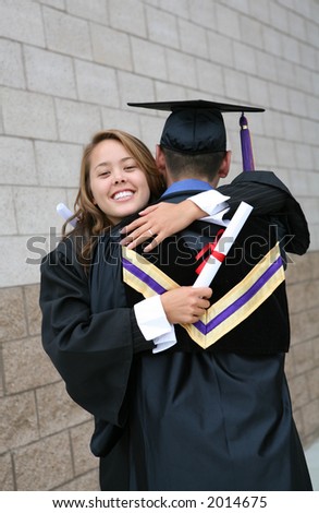 Two students celebrating their graduation with a hug