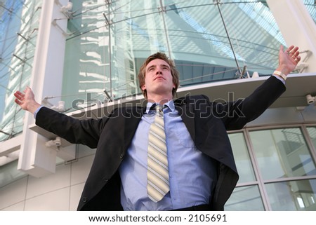 A business man celebrating success outside his office building