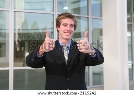 A business man with his thumbs up indicating success (Focus on Thumbs)