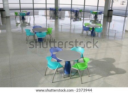 A cafeteria interior inside a high tech office building with colorful chairs