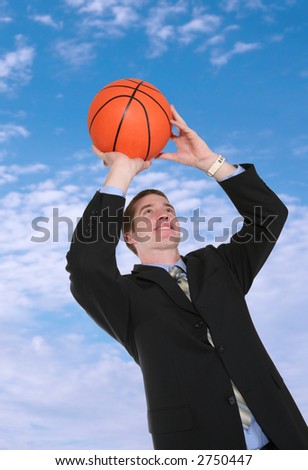 A handsome business man shooting a basketball playing sports
