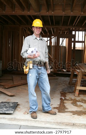 A home contractor holding blueprints outside a home in progress