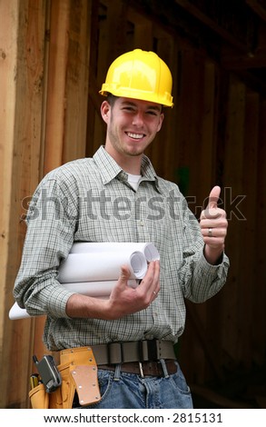 A home contractor holding blueprints outside a home in progress