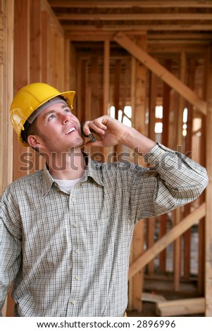 A handsome construction worker on the job and on the phone
