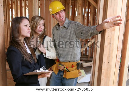 Construction worker showing house to real estate agents (Focus on Woman on Left)