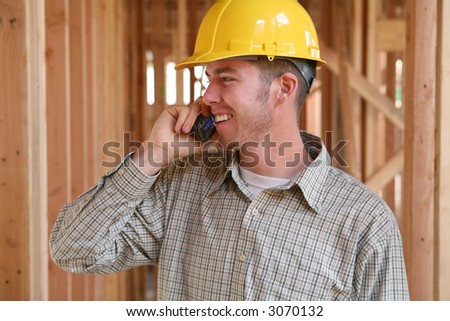 A handsome construction worker on the job and on the phone