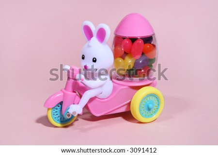 An easter bunny toy with cart and carrying a load of jelly beans