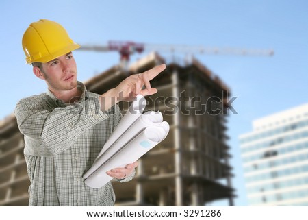 A construction worker with a building and crane in the background