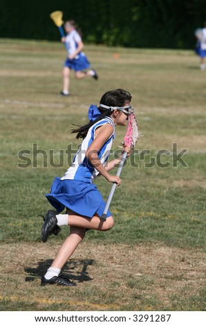 A young girl playing the sport of lacrosse