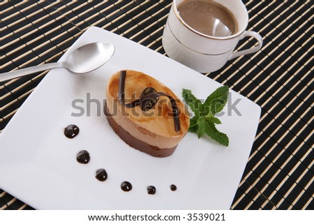 A chocolate flavored cake tart dessert on a plate with coffee