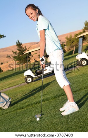 A pretty woman golfer ready to hit on the fairway