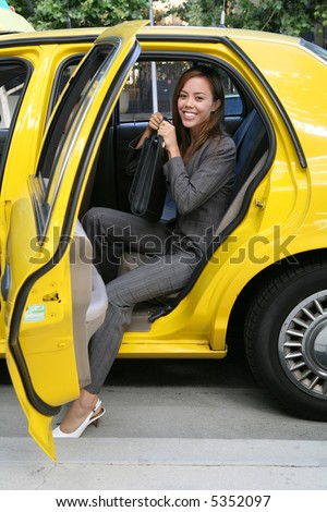 stock photo A pretty business woman getting out of a taxi cab