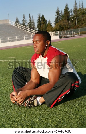 A strong football player stretching before the game