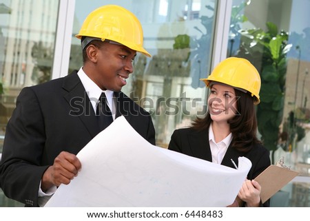 A young man and woman working as  architects on a building site