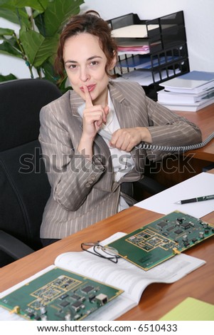 A business sales woman requesting silence while on the phone