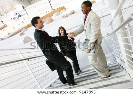 Two handsome business men shaking hands to confirm a deal