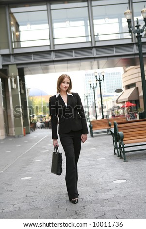A pretty blonde business woman walking to work