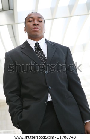 A young, handsome business man standing outside his office building