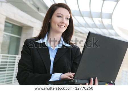 A pretty business woman on laptop computer  at office building
