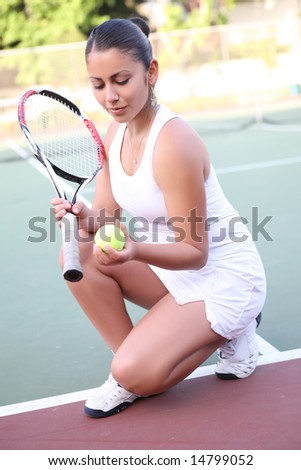 A pretty young woman playing tennis outdoors